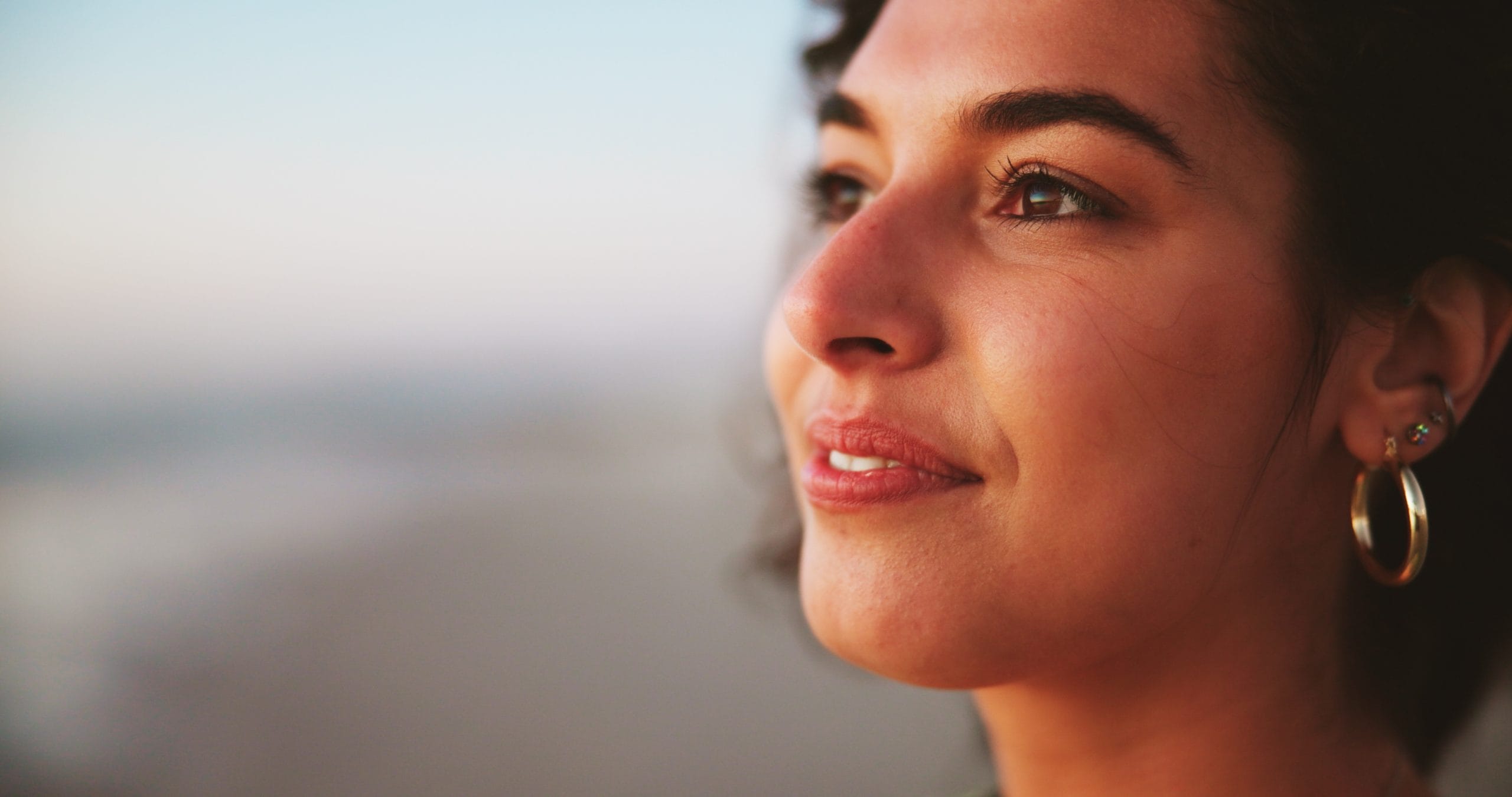 Woman smiling at the beach after attending a detox assessment.